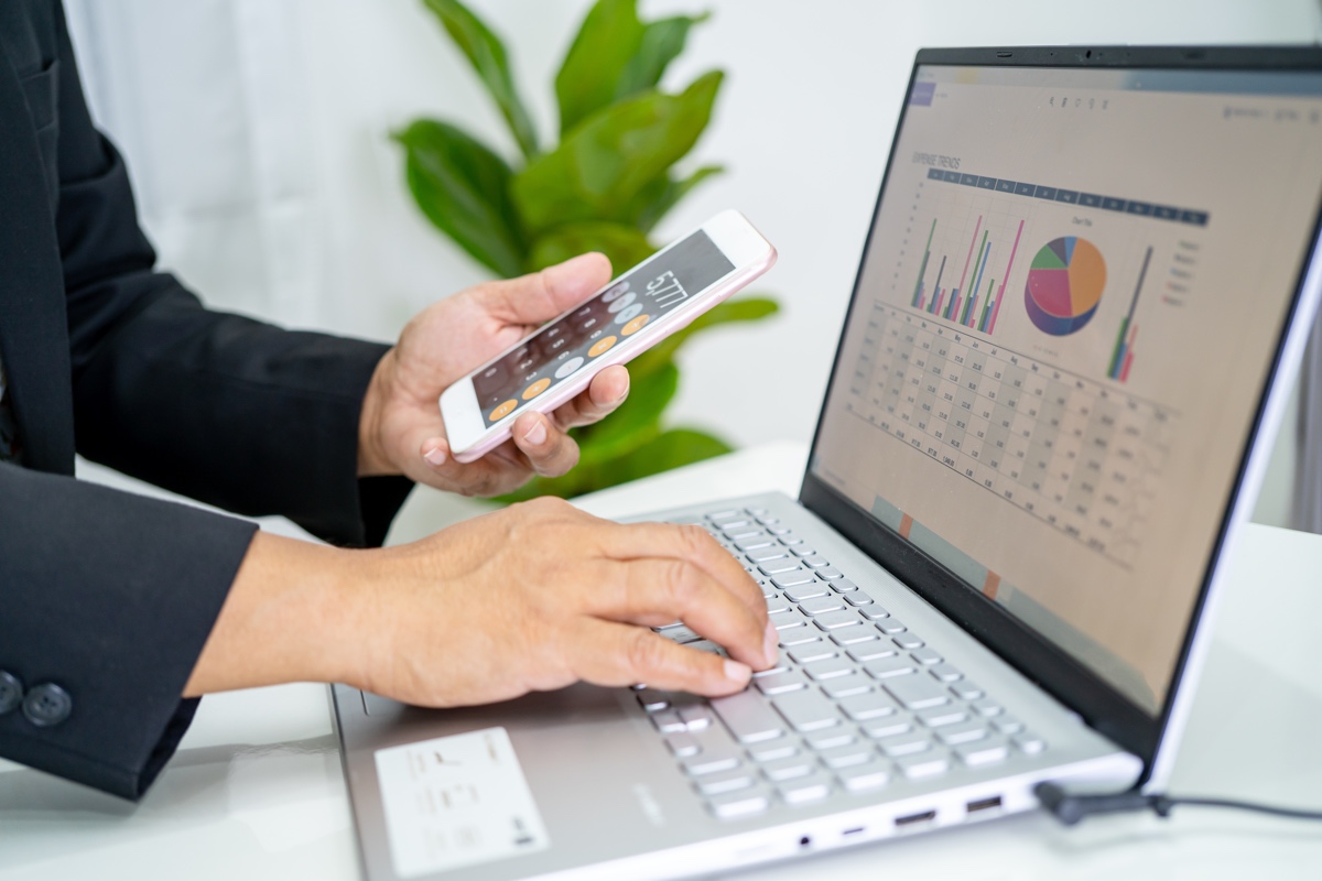 Asian accountant working and analyzing financial reports project accounting with chart graph and calculator in modern office, finance and business concept.