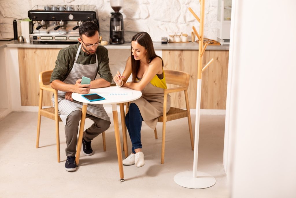 Husband helping wife with accounting after opening cafeteria